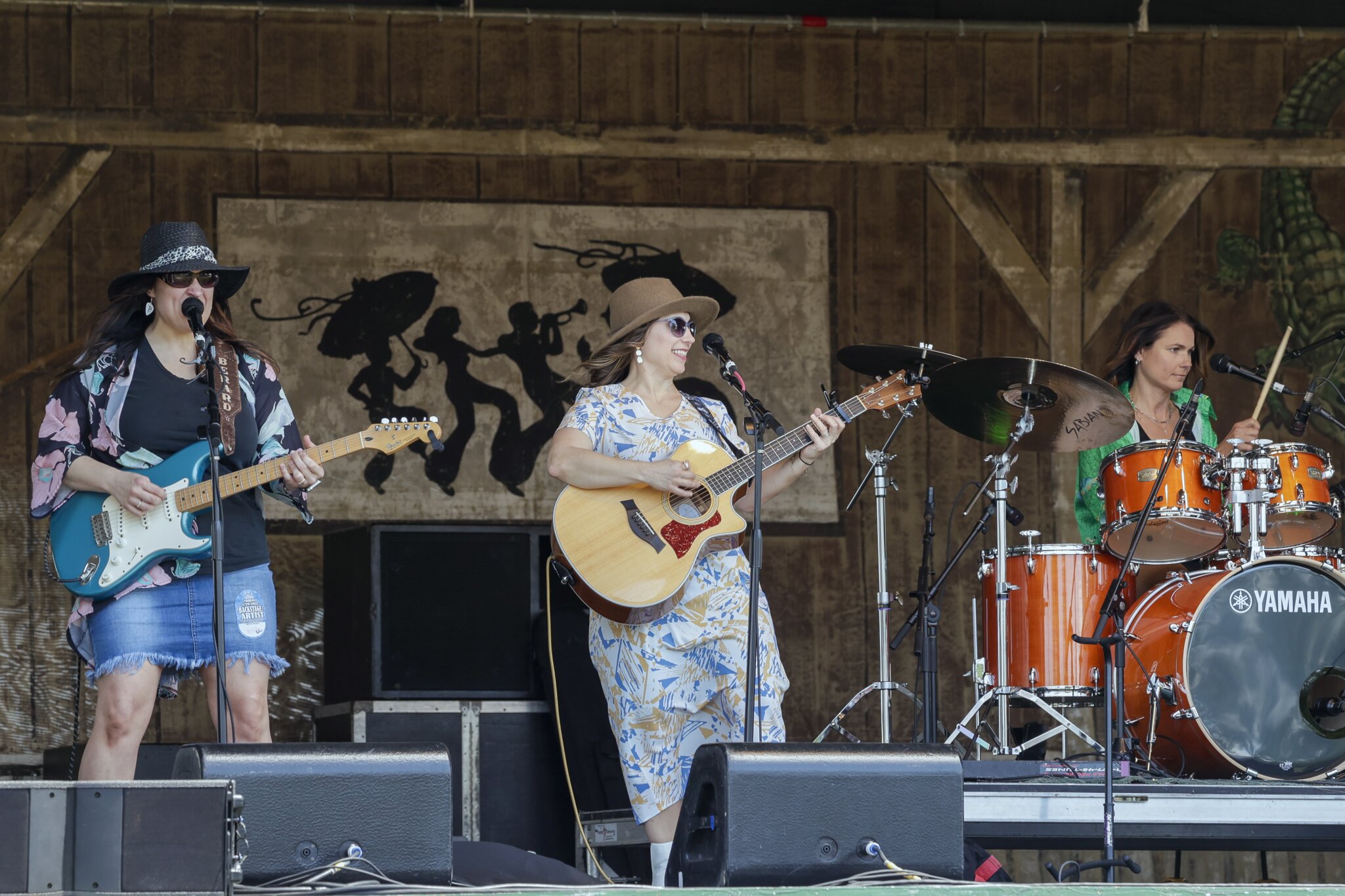 Singer playing guitar on stage during Jazz fest
