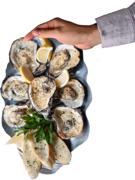 A hand holding a tray of Charbroiled Oysters