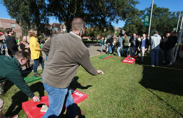 Students playing cornhole on a well-shaded outdoor lawn at Southeastern Louisiana University.