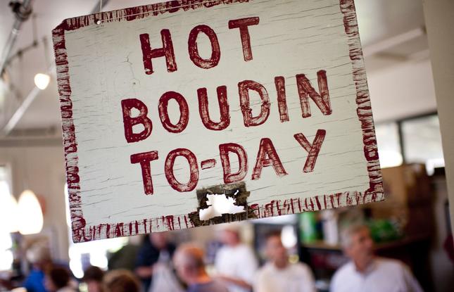 A sign reading “Hot Boudin To-Day” in red paint at Johnson's Boucanière in Lafayette.