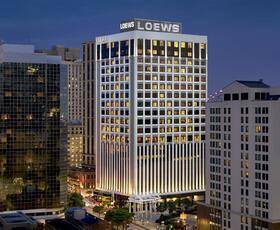 The exterior of the Loews Hotel in New Orleans at night.