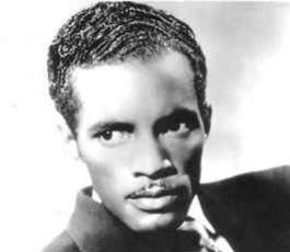 A portrait of Percy Mayfield in a suit and tie. He looks off into the distance.