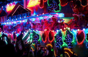 People wear glowing necklaces at the Bacchus Parade in New Orleans